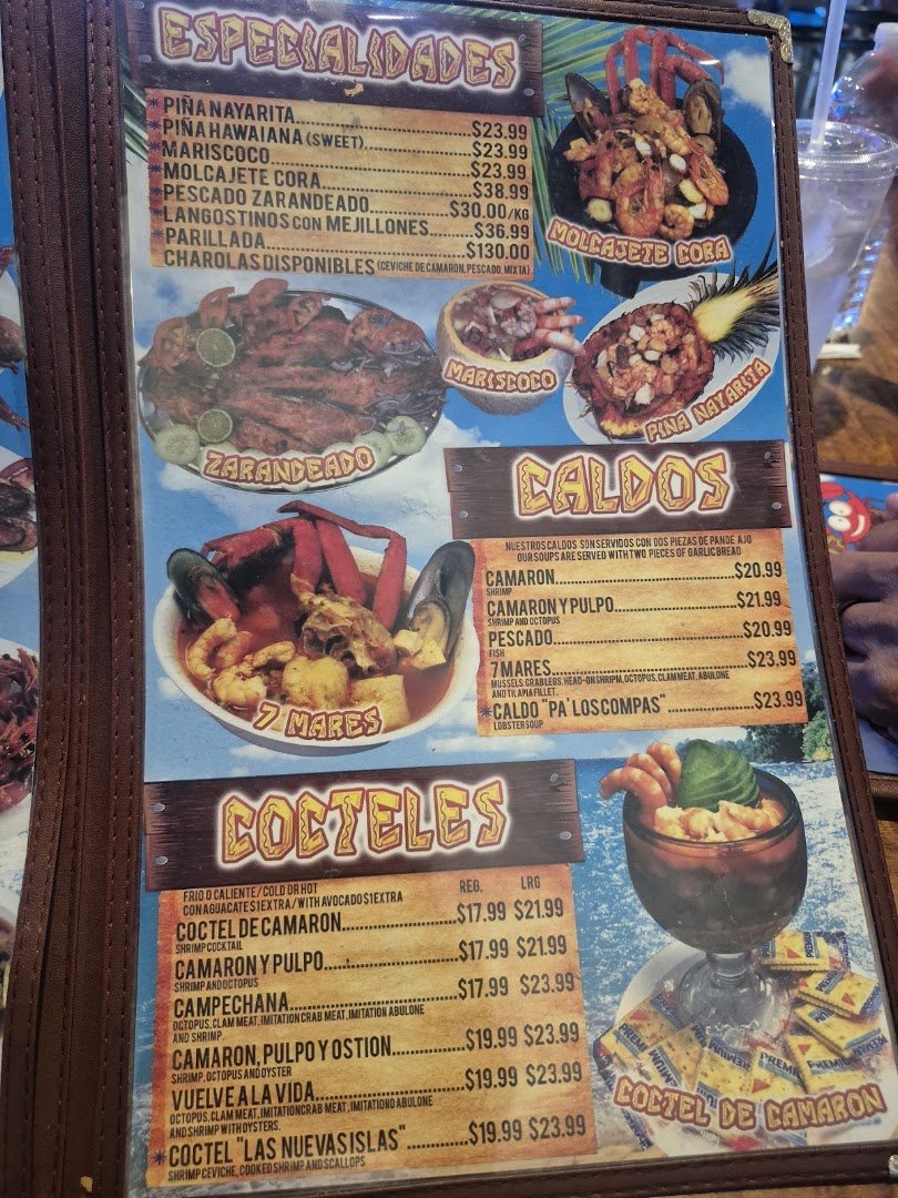 Seafood dishes beside chilled drinks and lime wedges.